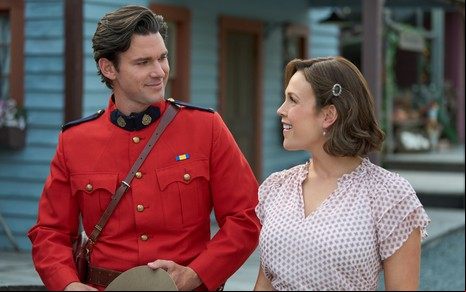 Kevin McGarry e Erin Krakow posam sorridentes com os figurinos de Quando Chama o Coração