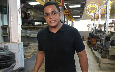 Marcelo Pereira usa uma camiseta preta e está num galpão cheio de as de barro