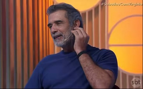 O ator Marcos Pasquim com mão no ouvido, expressão constrangida em participação no programa Sabadou