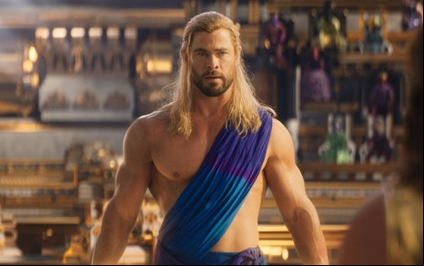 Chris Hemsworth está sem camisa, com uma túnica cobrindo parte de seu ombro