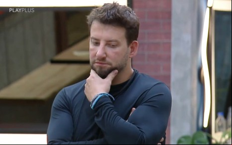 Eros Prado tem expressão concentrada na sala do Power Couple