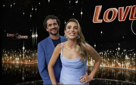 Felipe Andreoli e Rafa Brites sorriem para a câmera no cenário do Love & Dance