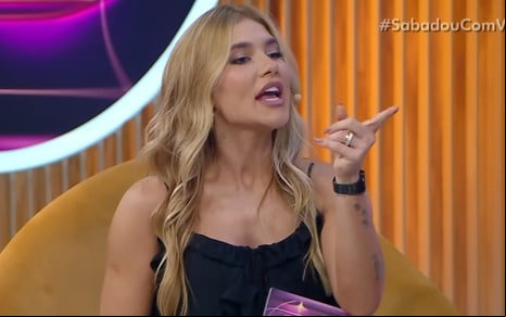 Virginia aponta o dedo em riste para o lado, com expressão de confronto, no cenário do Sabadou