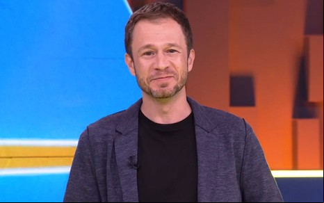Tiago Leifert sorri no cenário do Big Brother Brasil