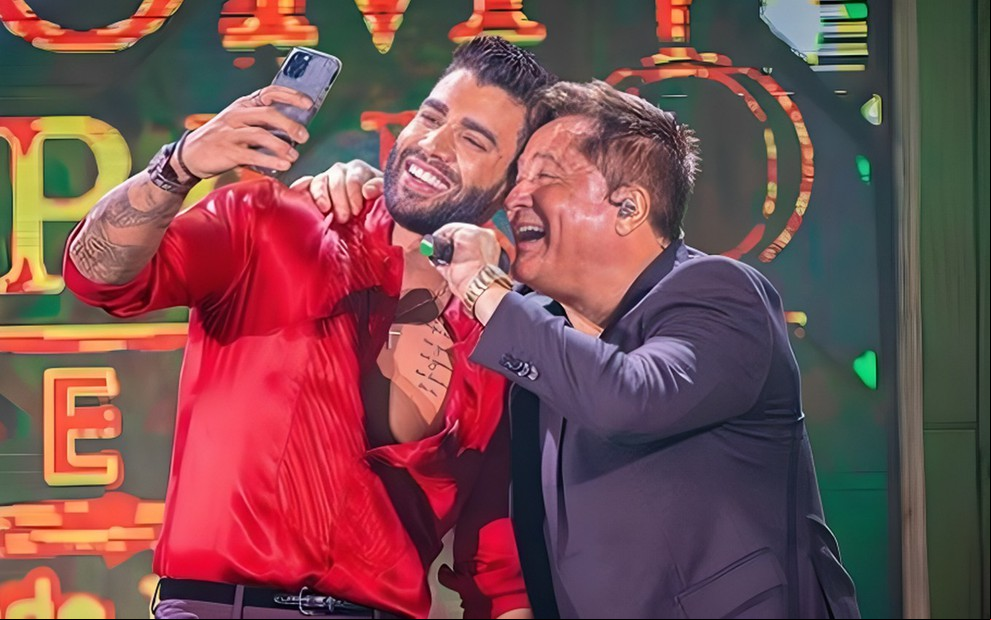 Gusttavo Lima e Leonardo posam sorridentes para selfie enquanto cantam em live